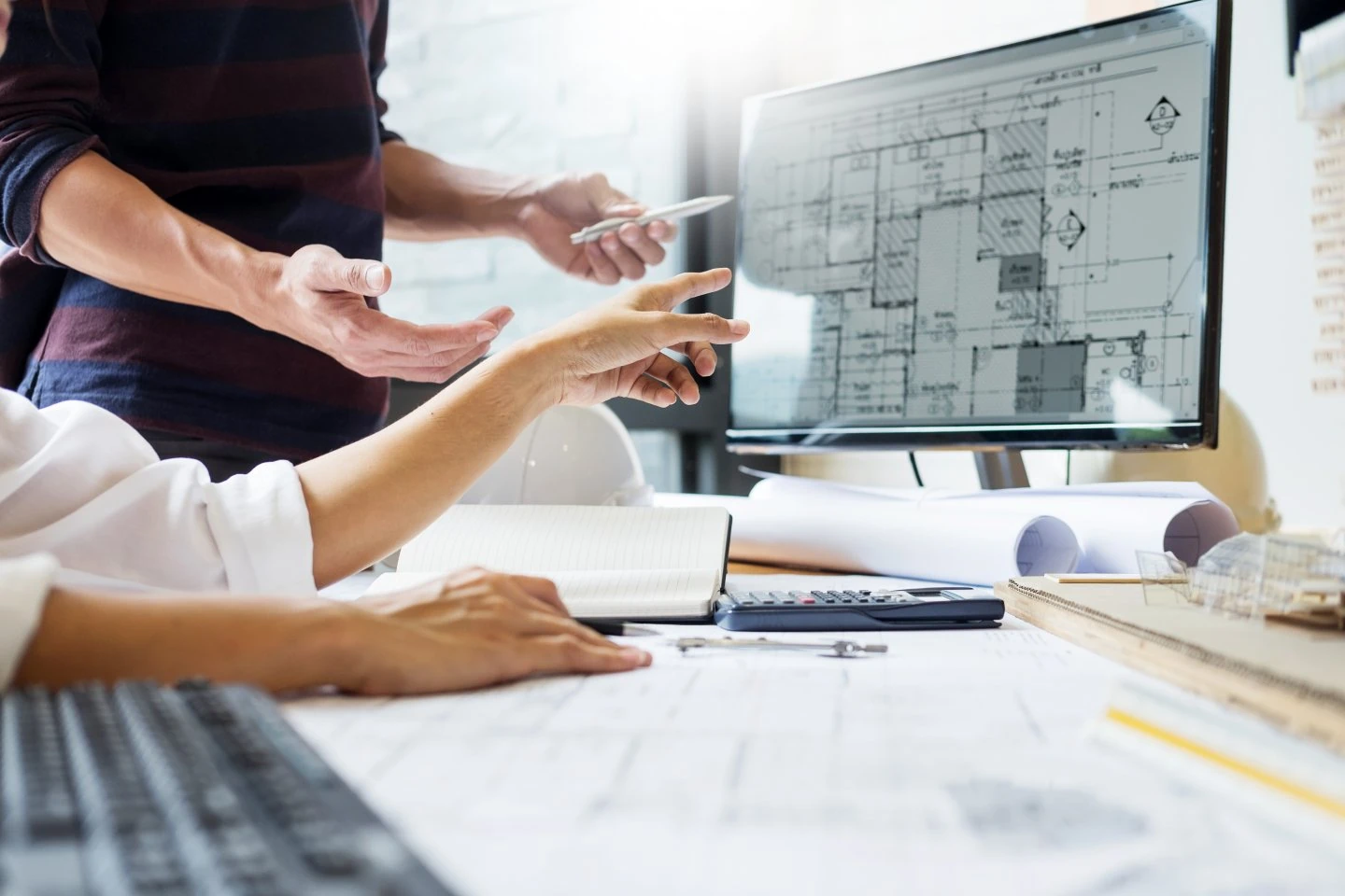 Échange professionnel autour de plans et d’un écran